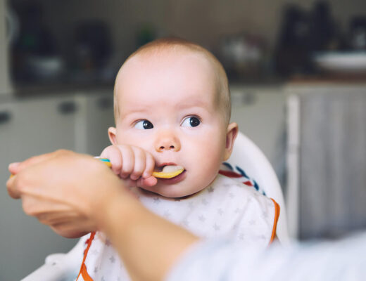 Ein Baby wird mit einem Löffel Brei-Beikost gefüttert.